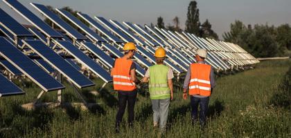 Solar panel engineers walking around field of solar panels