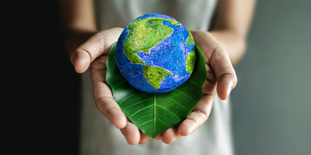 Hand holding the earth and a leaf